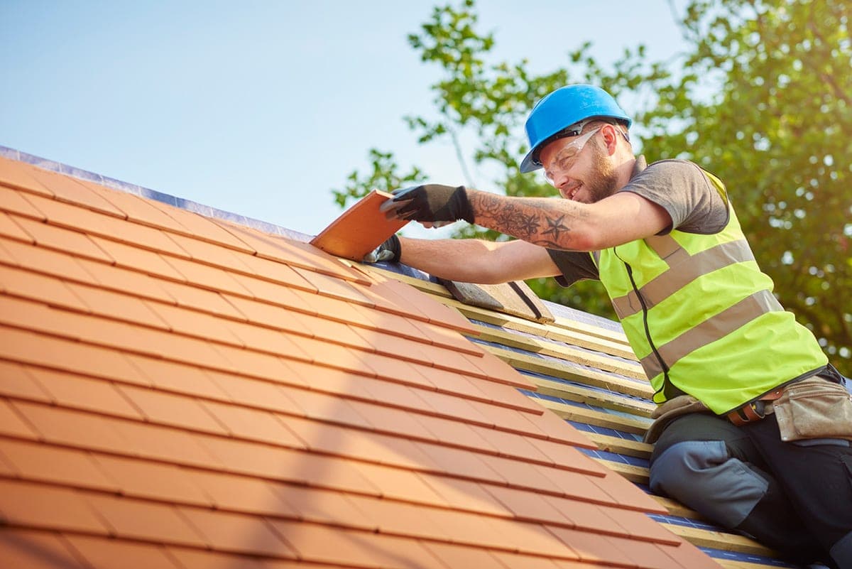 Am Norfolk Roofing Services roofer laying roof tiles